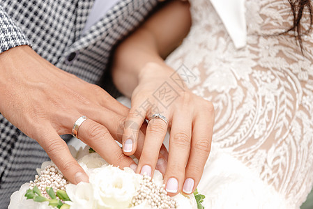 新婚夫妇手牵着手 手牵手在前景 年轻夫妇手的特写 无名指上戴着结婚戒指幸福新人夫妻钻石未婚夫妻子庆典蜜月金子女性图片
