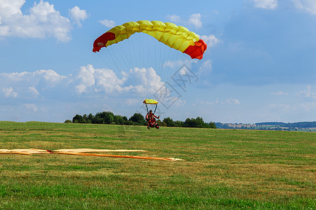 空降员成功降落在绿色草地上 空中运动和娱乐活动翅膀天篷乐趣跳伞自由机场风险跳伞员男人速度图片