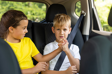 快乐的孩子 可爱的蹒跚学步的女孩和十几岁的弟弟坐在现代汽车里 锁着安全带 享受夏季周末的家庭度假旅行姐姐喜悦带子兄弟童年孩子们腰图片