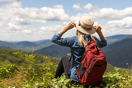 女孩旅行者徒步旅行 背着背包 在岩石山景 旅行生活方式概念冒险 暑假户外阳光远足踪迹旅人远足者天空享受悬崖假期运动图片