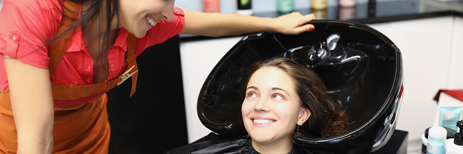 妇女理发师与客户在理发店附近交流图片