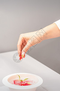 美容师用花瓣准备修指甲浴化妆品玫瑰疗法女性香味化妆师指甲闲暇健康香气图片