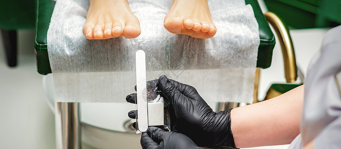 手拿的指甲文件工具成人赤脚广告两个人病学身体程序呵护服务美容师图片