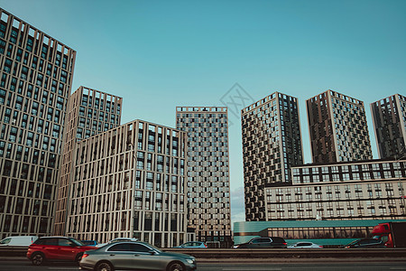商业区现代摩天大楼的底部景色与蓝色天空相对 抬头看商业建筑 在公路上移动交通图片