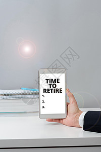 写作显示文本退休时间 商业展示以养老金领取者身份停止在足够大的老年人中工作重要信息在手机上靠在书本和笔记本上图片