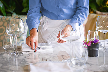 服务于豪华餐厅空桌的女服务员桌面风格午餐餐巾餐具桌布设置银器盘子食物图片