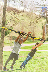 健身夫妇在公园用Trx健身带进行手臂运动的全长视力图片