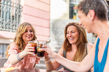 中年成年妇女在一家咖啡馆里 在外边喝着酒和吐司图片