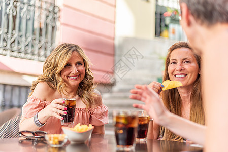 中年成年妇女与朋友聊天时喝酒的中年成年人图片
