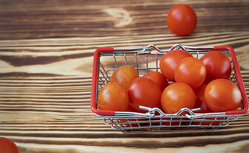 小樱桃西红柿在杂货篮里 用木制烧焦的本底零售纤维购物销售饮食圆形杂货车生长网上购物产品图片