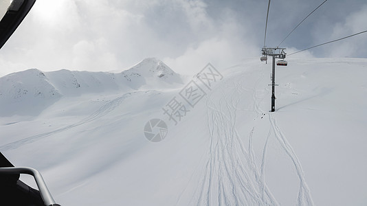 在阳光明媚的冬季日子里 有滑雪和雪板足迹的冰雪山坡 在高山上自由航行运动下坡小路踪迹娱乐单板天空白色季节爬坡图片