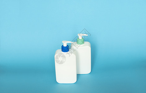 白色化妆塑料瓶 有蓝色背景的黑色泵喷雾器 液体容器用于凝胶 润滑剂 奶油 洗发水 浴泡沫图片
