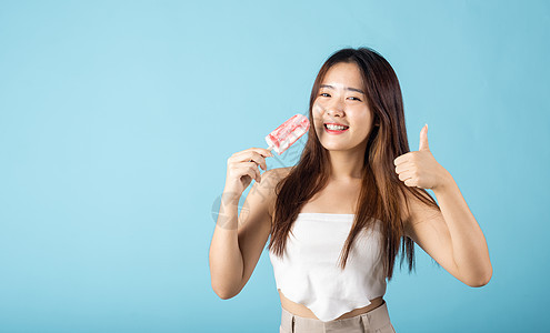 带着美味的冰淇淋木棒的亚洲快乐年轻美丽的女士食物旅行女孩奶油水果甜点棒冰乐趣木头幸福图片