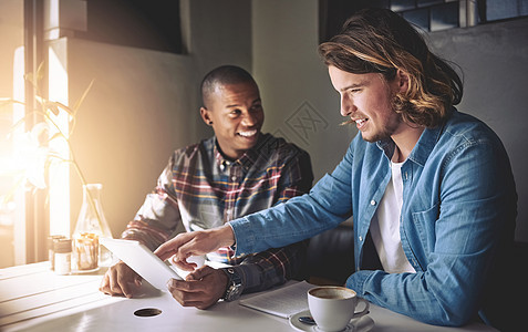 创新的触摸屏技术 两个朋友在咖啡店喝咖啡时用平板电脑做客背景图片