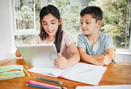 孩子们使用数字平板电脑学习教育 以便在家一起完成在线学校作业或家庭作业 智能远程学习学生 兄弟姐妹的孩子或兄弟姐妹帮助上课图片