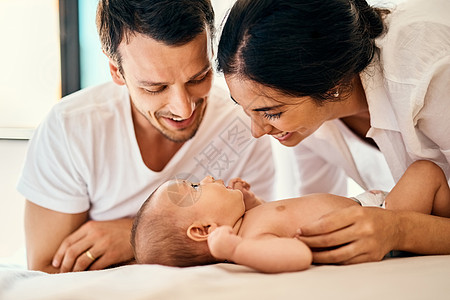 生于幸福之家 一个快乐的母亲和父亲在家里与他们的男婴建立联系图片