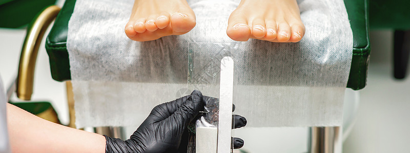 手拿的指甲文件工具身体服务沙龙部位美容师脚趾温泉横幅治疗病学图片