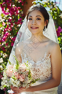 鲜花与她的裙子吻合 是一位快乐的年轻新娘的肖像 白天站在外头时拿着一束花束图片