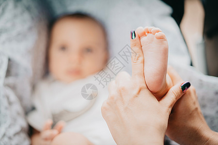 母亲亲手握着小婴儿男孩的脚 新生儿概念新生母性毯子手指男生童年脚趾身体棕榈皮肤图片
