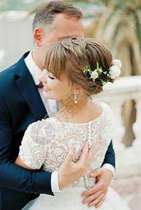 Groom拥抱着微笑的新娘 近一点图片