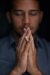 转而信仰去寻找希望和慰藉 一个年轻人在祈祷时握着他的双手图片