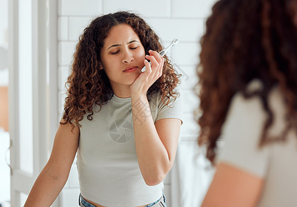 早上刷牙的女性会出现牙痛 口腔疼痛和牙齿敏感 非洲裔美国女性在浴室里嘴里有疼痛 疼痛或炎症图片