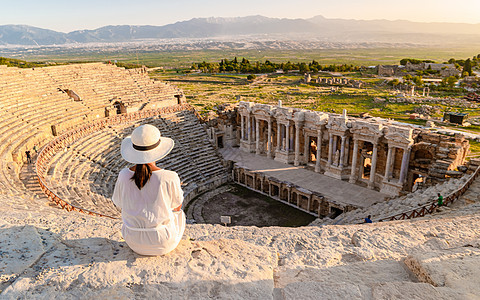 Hierapolis 古城Pamukkale土耳其 年轻女性戴帽子观看日落的废墟Unesco考古学游客剧院古董火鸡城市历史性柱廊图片