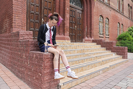 校服穿制服 背背背背包使用智能手机的女学生图片