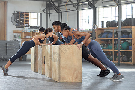 团体训练 倾斜俯卧撑和自重锻炼 锻炼和健身 在带有增强式跳箱的体育课上进行 有耐力 精力和健康挑战的运动型 强壮和活跃的人图片