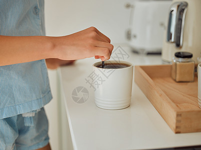 在室内的厨房柜台上制作新鲜 热的早晨咖啡 开始新的一天 与一位穿着睡衣站在家里的女性一起准备温暖的饮料和饮料的手部特写图片