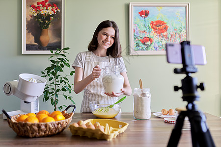 做橙子煎饼 倒牛奶的年轻女孩食物博客图片
