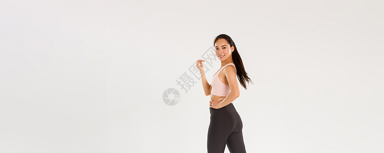 时髦苗条的黑发亚洲女孩的全长肖像画 她在健身 在健身房锻炼 带着积极而坚定的表情走路 在体育中心有会员资格肌肉女性身体情绪运动员图片