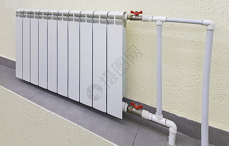 用于热水加热的白色现代铝散热器电池 位于公寓或办公空间内部墙壁的背景上地面调节器力量散热器房间管道技术活力房屋控制图片