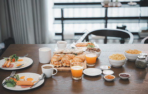 早餐供应食物 饮料咖啡 橙汁 在上午餐桌上在回家的清晨酒店羊角家庭果汁熏肉黄油肉桂饮食餐厅盘子图片