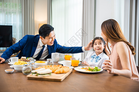 亚洲家庭父亲 有孩子的母亲早上在餐桌厨房吃早餐图片