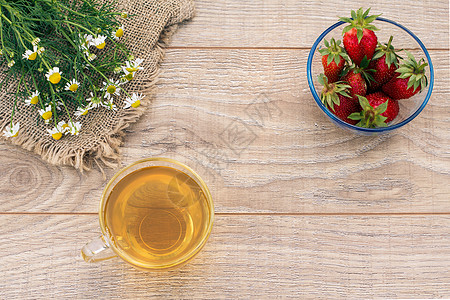 一杯绿茶 白甘菊花的石莓 木制背景上母菊杯子洋甘菊玻璃早餐草本植物植物药品食物饮食图片