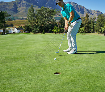 男人运动一个有重点的年轻人 撞上高尔夫球 然后用推土机钻进高尔夫球场上的洞里背景