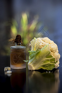 黑面上一个小玻璃瓶里有选择性的焦点 创意照明和模糊的背景 紧贴地拍下生菜花及其基本油料的镜头农业食谱香味植物油萃取实验室收成养分图片