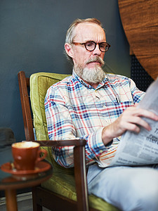 咖啡和报纸 我多么喜欢开始我的下午 一位老人在咖啡店看报纸和喝咖啡图片