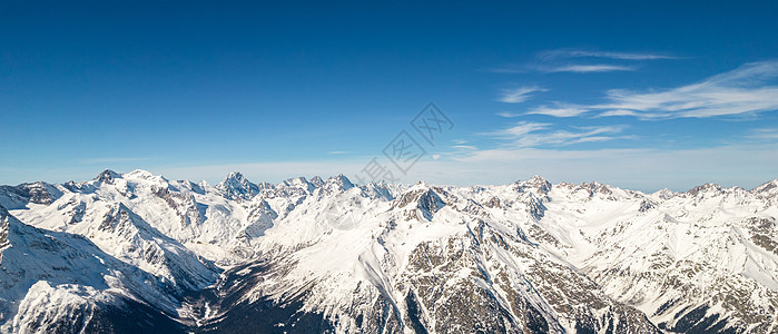 俄罗斯高加索地区蓝色天空背景的雪寒冬山山脉全景图片