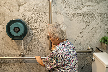 亚洲老年或老年老妇人病人在护理医院病房使用厕所浴室手柄安全 健康强大的医疗理念栏杆潮红卫生间医院汽车扶手退休淋浴铁轨洗手间图片
