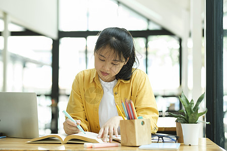 认真的年青学生在读一本准备考试的书学校学习导师阅读中学教育大学图片