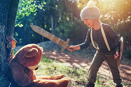 我是来救你的 Teddy 一个可爱的小男孩 在外面拿着纸板剑和盾牌玩耍图片