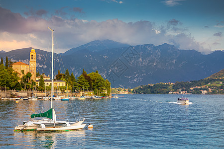 与Tremezzo村和帆船在意大利阳光明日的Como湖海岸线爬坡景观村庄快艇码头教会航行支撑地方花园图片