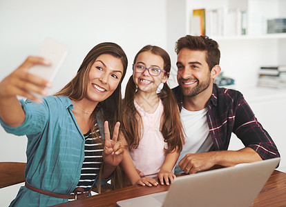 为自拍微笑 甜心 一对幸福的已婚夫妇和他们年幼的女儿在家里摆姿势自拍图片