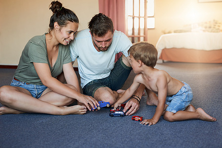 玩耍时间是家庭事务 一个小男孩和他父亲在家玩玩具车图片