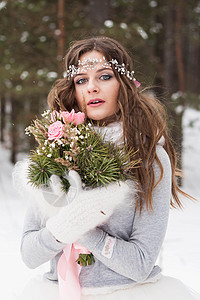 穿着白裙子的美丽新娘 在雪覆盖的冬季森林中穿着花束带 自然界新娘的肖像童话装饰玫瑰女性乡村女士庆典化妆品宴会仪式图片