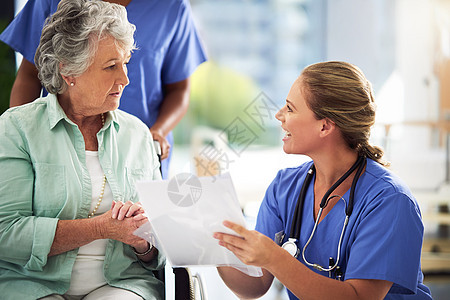 让她的病人了解情况 在医院里 一位医生与一位坐在轮椅上的老年妇女讨论治疗方法图片