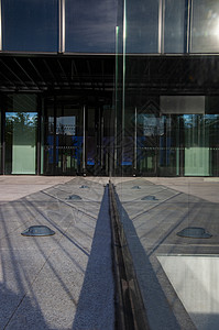 办公室入口处的对称玻璃光反射背景图片