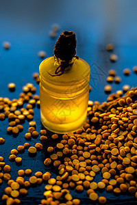 玻璃瓶里的精炼小鸡皮油 在光亮的黑木头表面 用生黄扁豆来配食品异域营养瓶子美食食物化妆品身体玻璃饮食图片